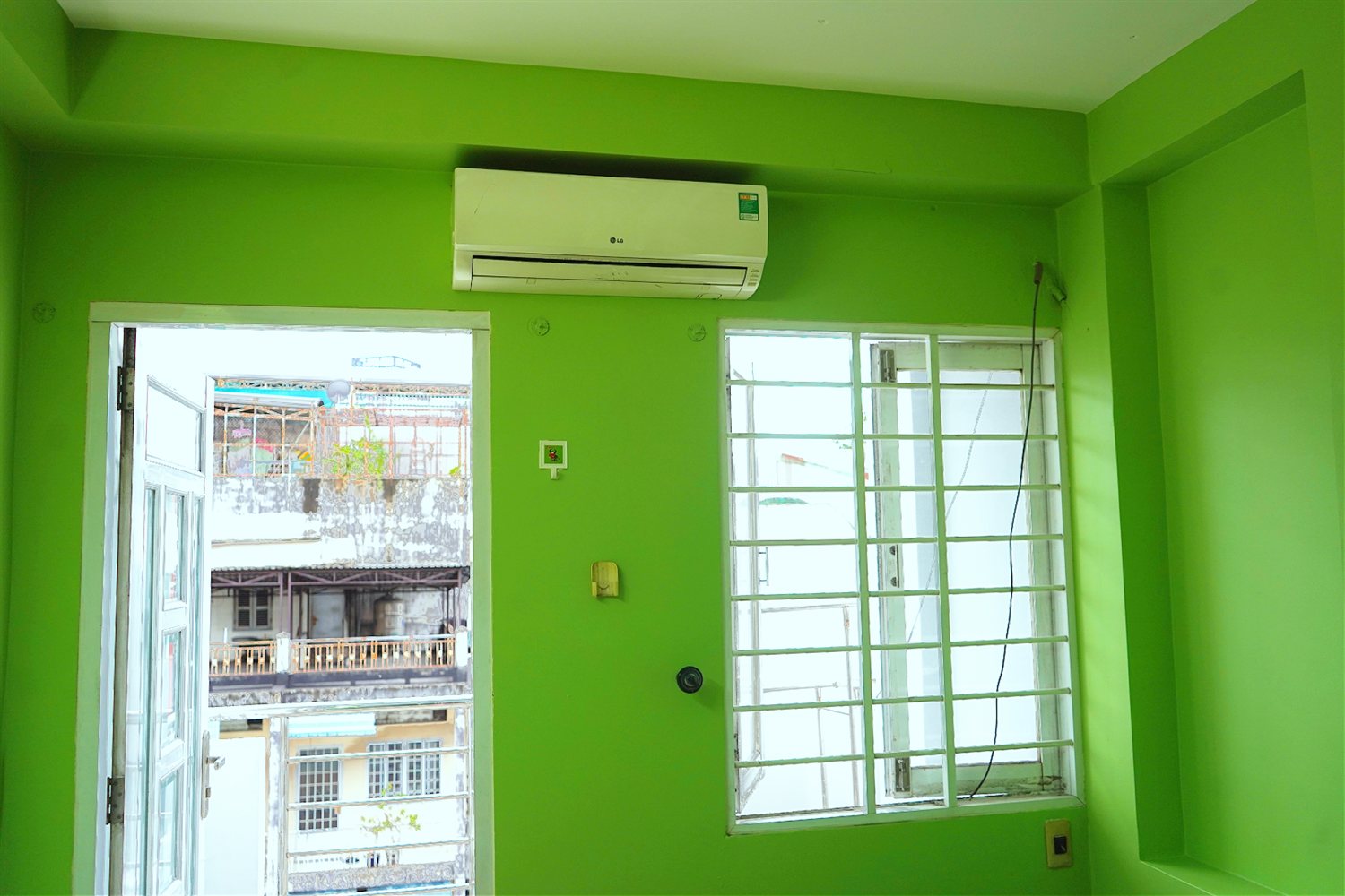 Căn phòng sau khi khách tự sơn — tường xanh lá tươi mới, sáng bừng