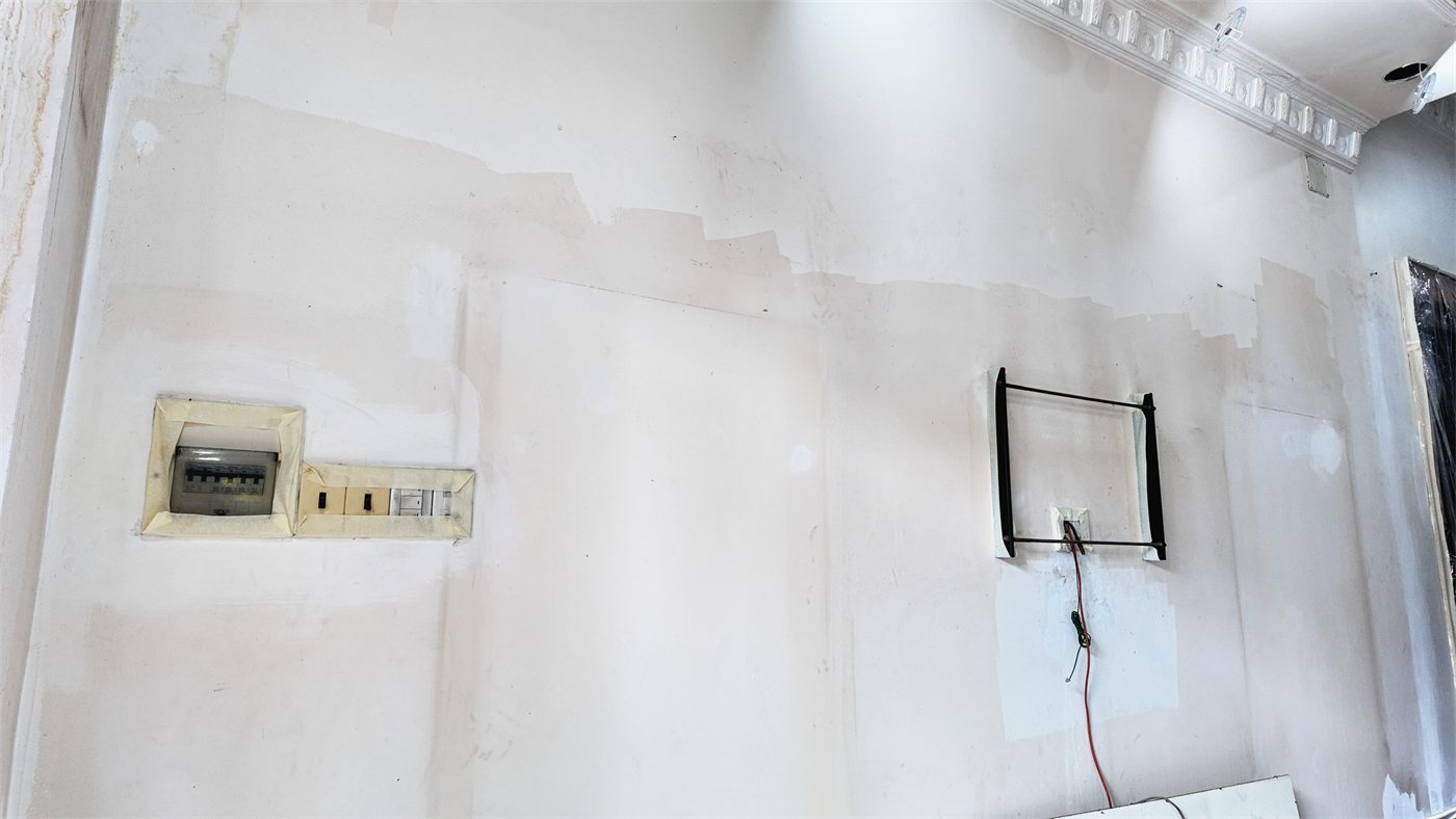 Mảng tường sạch, cửa gỗ gọn gàng — tường đang dùng bình thường, hợp để tự sơn lại